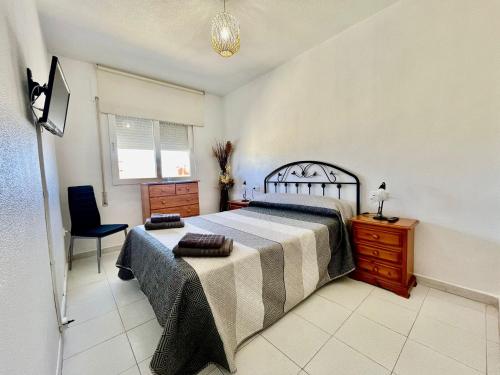 a bedroom with a bed and a desk and a chair at Ático Ola Azul in Los Alcázares