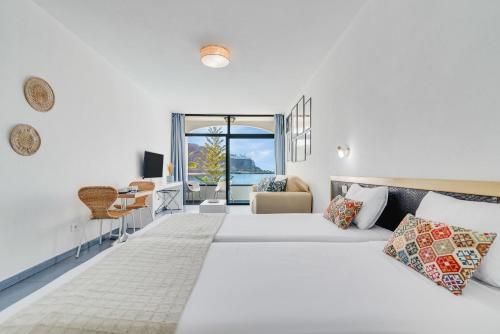 a white bedroom with a large bed and a window at Paradise Playa del Cura in Las Palmas de Gran Canaria