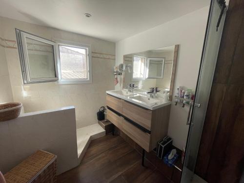 une salle de bain avec un lavabo, un miroir et une baignoire dans l'établissement Les Terrasses du Barreau, à Mèze