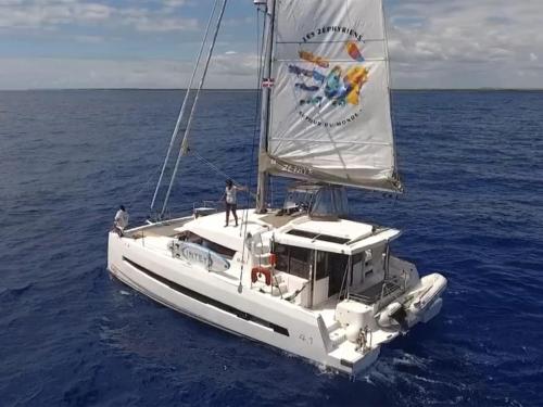 a sailboat in the ocean with two people on it at Your half-day cruise with scenic Zephyr and water activities in Grand Case