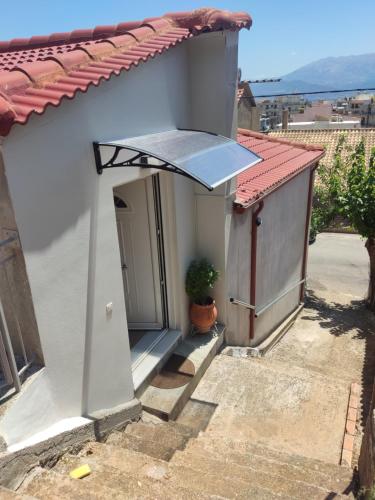 a small white house with a window and a roof at Travelers Stasis Nafpaktos in Nafpaktos