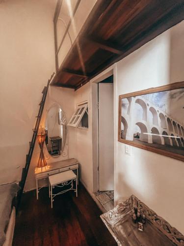 a room with a staircase with a table and a mirror at Casa Tuxi in Rio de Janeiro