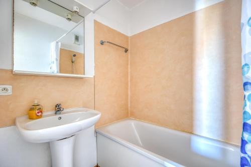 a bathroom with a sink and a mirror and a tub at Les Vertmarines in Le Verdon-sur-Mer