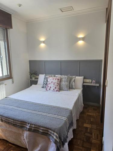 a bedroom with a large bed with pillows on it at Villa Papona 1 in Moaña