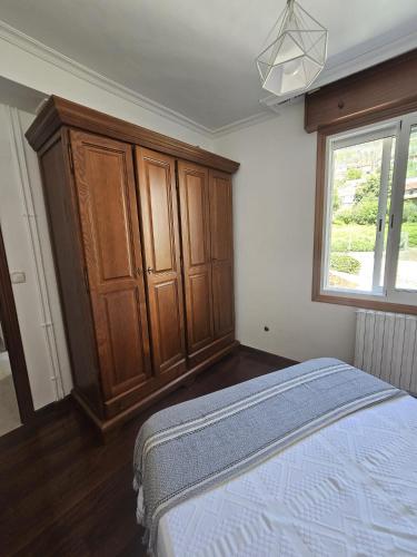 a bedroom with a bed and a wooden cabinet at Villa Papona 1 in Moaña