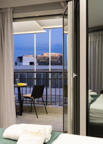 a bedroom with a balcony with a view of the ocean at Evripidou Suites in Athens