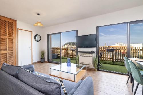 un salon avec un canapé et une télévision dans l'établissement Open Sky Terrace Lage 1 Bdr & Parking, à Nice