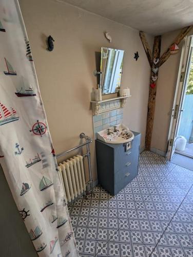 a bathroom with a sink and a mirror at The Old Shop Cottage, Llandudno in Penrhyn Bay