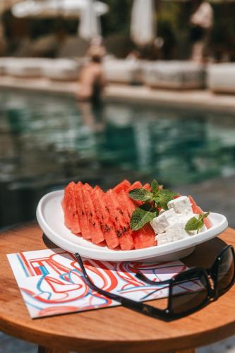 a plate of food on a table next to a pool at M Boutique Hotel - Designed for Adults in Paphos City