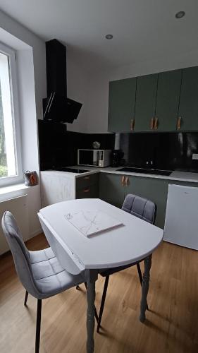 une table blanche et des chaises dans une cuisine dans l'établissement Escale Côte d'Amour, à Pornichet