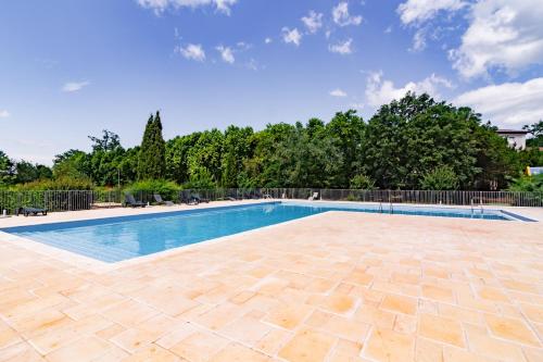 une piscine avec un patio carrelé et des arbres dans l'établissement Douceur de Jouarres - Avec piscine, à Azille