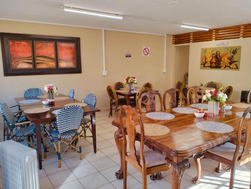 a dining room with wooden tables and chairs at Grace on 51York Lodge in Johannesburg