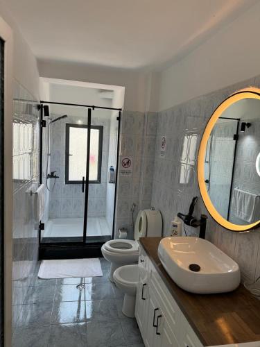 a bathroom with a sink and a toilet and a shower at Your house in Tirana in Tirana