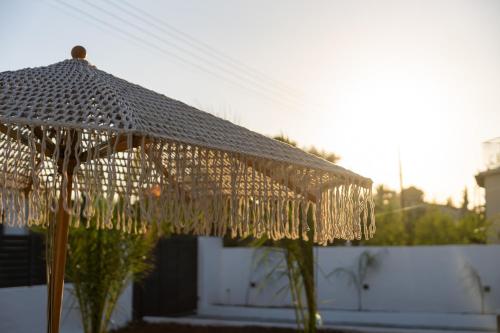 an umbrella that is covered in gold strings at Mezcal Private Pool Villa in Kalívia Thorikoú