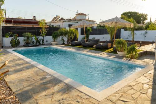 a swimming pool in the backyard of a house at Mezcal Private Pool Villa in Kalívia Thorikoú