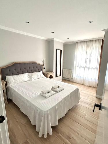 a bedroom with a large bed with two towels on it at Piso Playa de Los Barcos in Isla