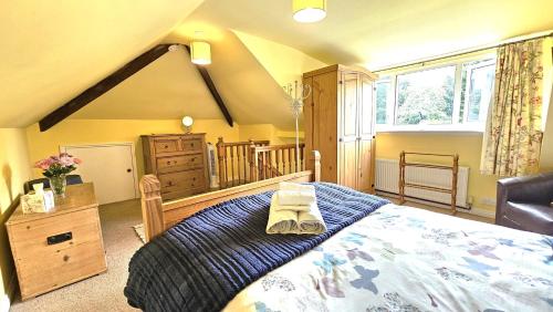 a bedroom with a large bed with a blue blanket at Beckside - Peaceful Garden House, Dog Friendly in York