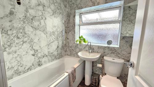 a bathroom with a sink and a toilet and a bath tub at Beckside - Peaceful Garden House, Dog Friendly in York