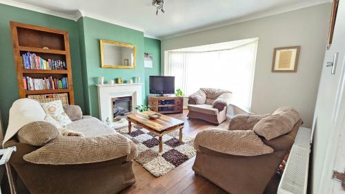 a living room with two couches and a tv at Beckside - Peaceful Garden House, Dog Friendly in York