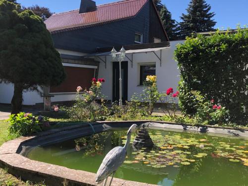 un uccello in uno stagno davanti a una casa di An Ferienwohnung a Lipsia