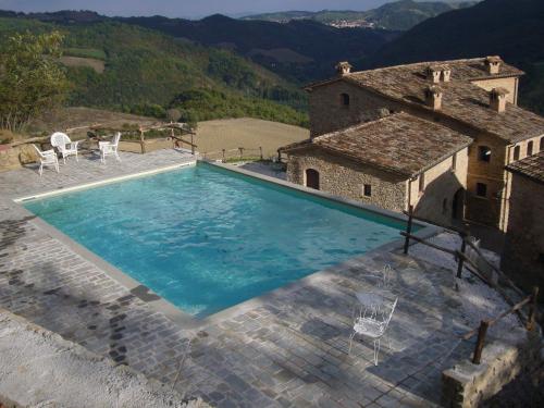 una grande piscina di fronte a una casa di Borgo Storico Cisterna a Macerata Feltria