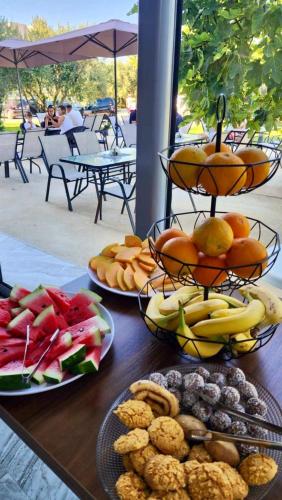 two plates of food on a wooden table with fruit at Sunrise Apart-Hotel in Ulcinj