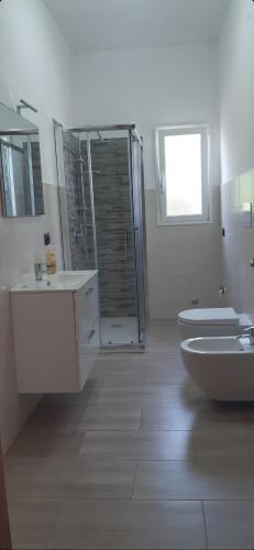a bathroom with two sinks and a shower and a toilet at Villa Salvina Beach in Fontane Bianche