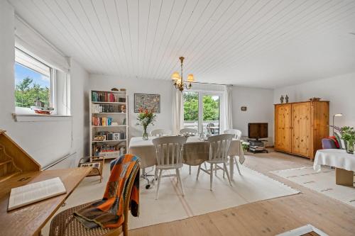 a living room with a dining room table and chairs at Cozy Holiday Home, Located In The Peaceful Area Of Klegod - 1038 in Ringkøbing