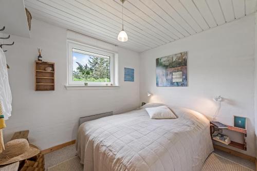 un dormitorio con una cama y una ventana en Cozy Holiday Home, Located In The Peaceful Area Of Klegod - 1038, en Ringkøbing