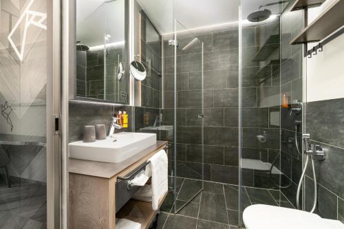 a bathroom with a sink and a shower at 24 by AvenidA - Mountain Hotel in Kaprun