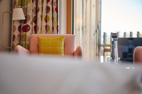 a couch with a yellow pillow in a living room at Genuss- & Aktivhotel Sonnenburg in Riezlern