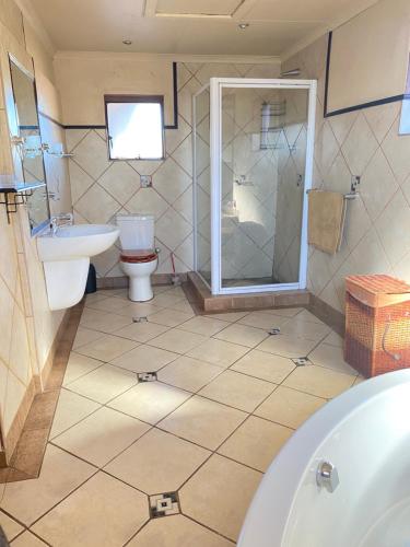 a bathroom with a tub and a toilet and a sink at The Red room in Phalaborwa