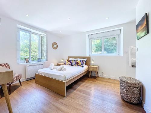 une chambre blanche avec un lit et deux fenêtres dans l'établissement Ker Lenn au bord d un etang, jolie propriete, à Guilers