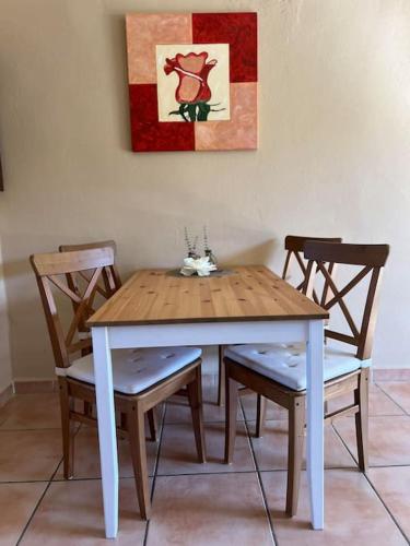 a wooden table with two chairs and a painting on the wall at Casa Andalucía - 3,5 Zimmer Haus unter den Sternen, Vivienda Rural VTARAL01059 in Sorbas