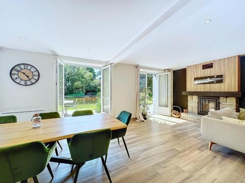 une salle à manger avec une table et des chaises et une cheminée dans l'établissement Ker Lenn au bord d un etang, jolie propriete, à Guilers