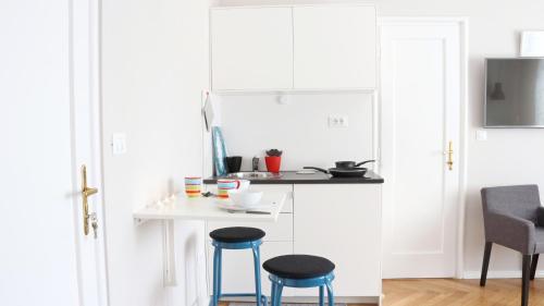 a kitchen with two blue stools next to a table at Park and Bike City Studio Zagreb in Zagreb