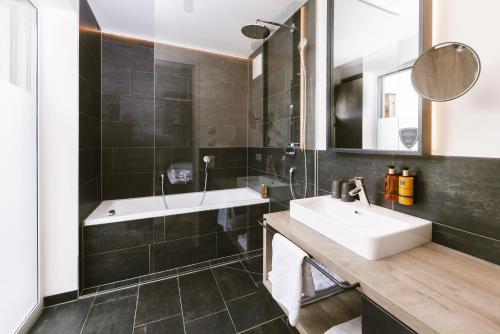 a bathroom with a sink and a mirror at 24 by AvenidA - Mountain Hotel in Kaprun