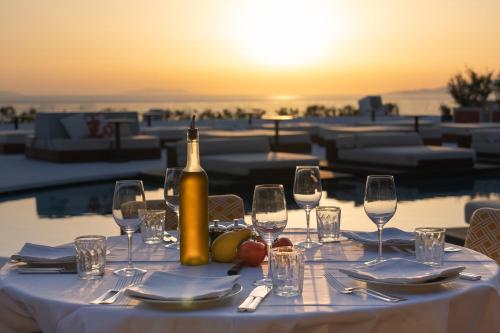 a table with a bottle of wine and glasses at Anandes Hotel in Mýkonos City