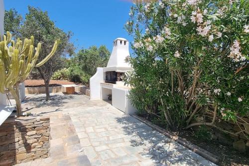 a garden with a stone walkway and a white oven at Villa Kalliopi Ambelas Paros in Ambelas