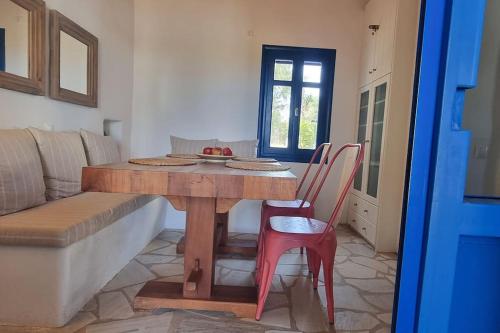 a table and chairs in a living room with a couch at Villa Kalliopi Ambelas Paros in Ambelas