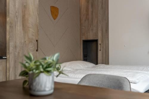 a bedroom with a bed and a table with a potted plant at 24 by AvenidA - Mountain Hotel in Kaprun
