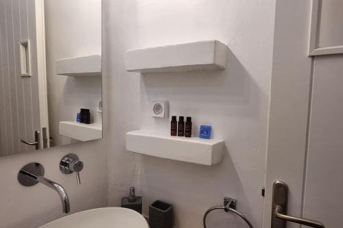 a white bathroom with a toilet and a mirror at Villa Kalliopi Ambelas Paros in Ambelas