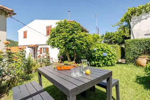 a gray picnic table in a yard with at Casa do Limoeiro 2 in Valezim