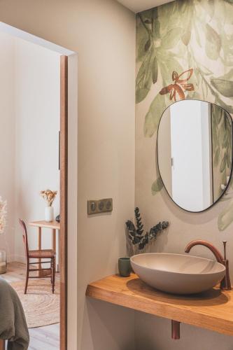 une salle de bain avec un lavabo et un miroir sur un comptoir dans l'établissement Maison Montaut, à Onesse-et-Laharie