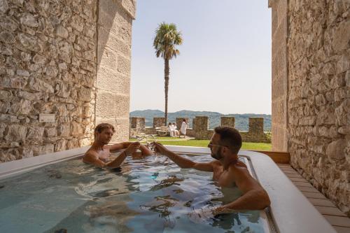 two men in a jacuzzi in a pool at CastelBrando in Cison di Valmarino