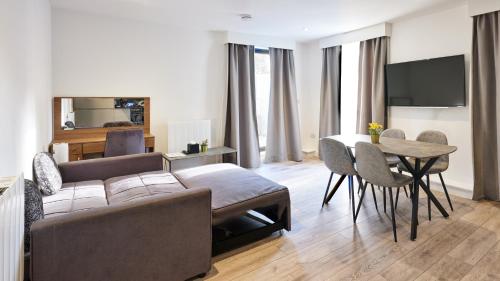 a living room with a couch and a table at Hampton Suites Serviced Apartments in Kingston upon Thames