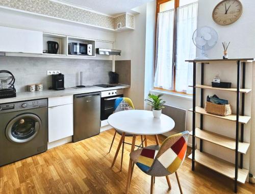 - une cuisine avec une table, une table et des chaises dans l'établissement Cosy appartement centre ville parking Netflix, à Montluçon