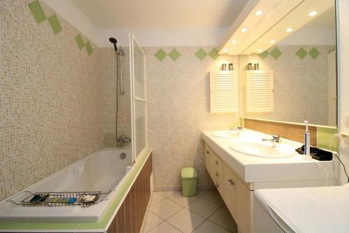 une salle de bain avec une baignoire, un lavabo et un miroir dans l'établissement Villa 8 pers,10min de la mer climatisée, à Argelès-sur-Mer