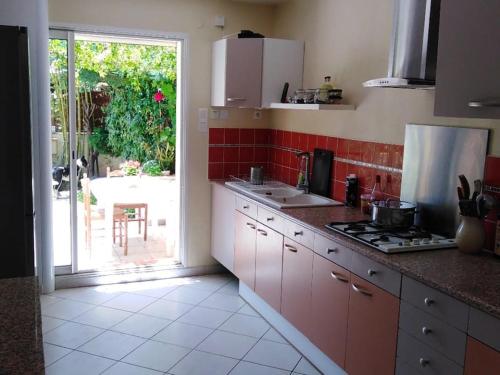 une cuisine avec un évier et une cuisinière four supérieur dans l'établissement Villa 8 pers,10min de la mer climatisée, à Argelès-sur-Mer