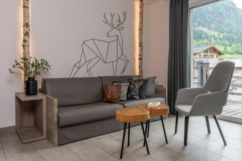 a living room with a couch and two chairs at 24 by AvenidA - Mountain Hotel in Kaprun